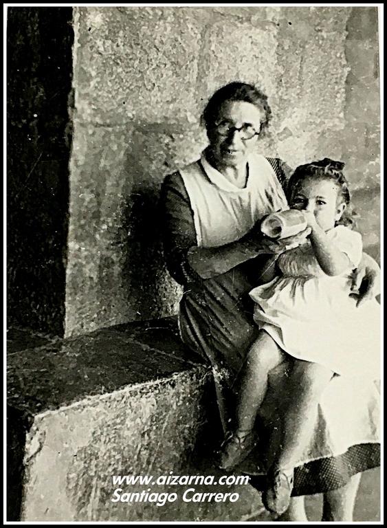 Zz-Margarita Egiguren  Bastida dando el bibern  en el prtico de la Iglesia ao 1945 Margarita Eguiguren haur txiki bat  besoetan duela 1945 urtean