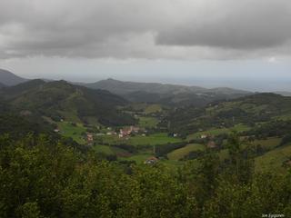 Hilero bezala, ekaineko bigarren egunean  ermitatik ateratako argazkia. Ekaina izateko eguraldi otza eta iluna zegoen, euria eta laino koska beltzak itsaso gainean hala ere Aizarna bailara polita ikusten da.  
